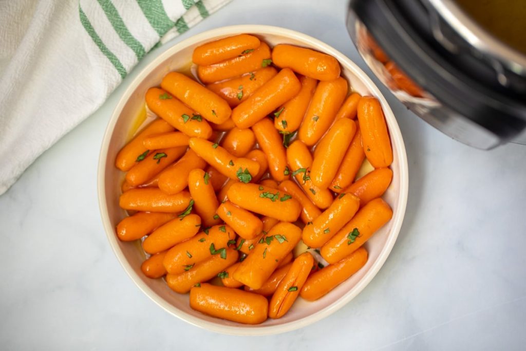 Bowl of glazed instant pot carrots topped with parsley.
